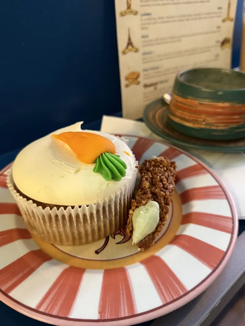 Carrot cake cupcake with cream cheese frosting on a striped plate at Toastea